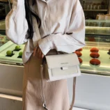 Multicolour PU leather square crossbody bag worn on shoulder in white