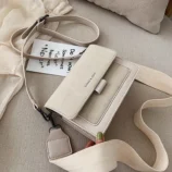 Multicolour PU leather square crossbody bag resting flat with decorative items