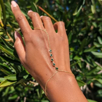 Elegant rhinestone finger bracelet worn gracefully on a woman's hand outdoors.