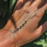 Multicolour rhinestone finger bracelet for women worn on hand featuring black stone accents.