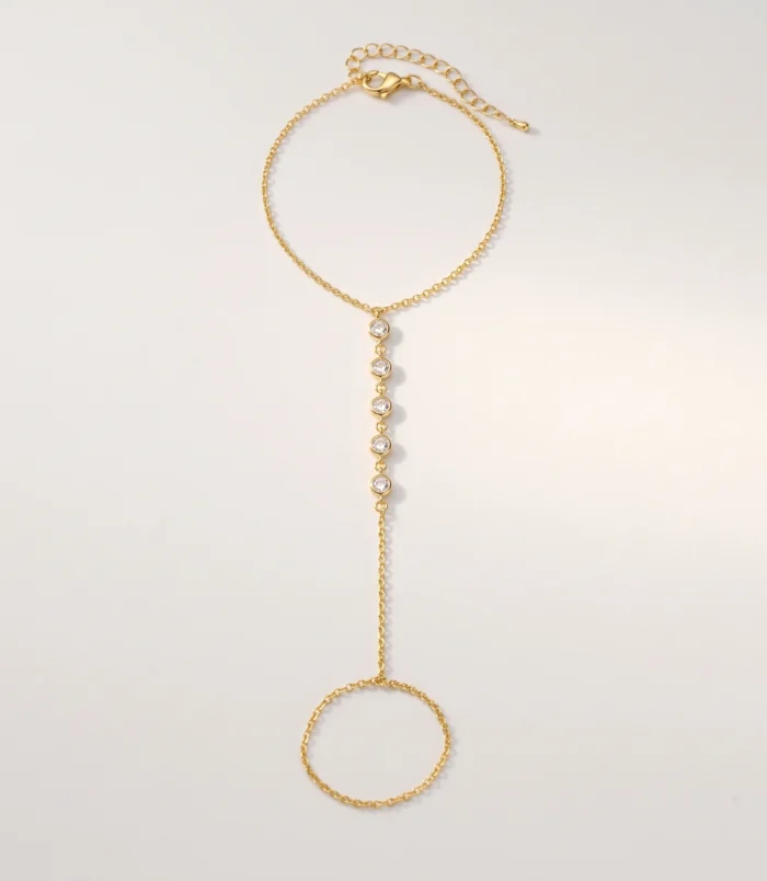 Multicolour rhinestone finger bracelet for women flat lay showing gold plating with clear white stones.