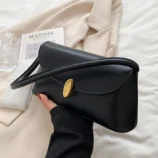 Black version of the small square bag held in hand