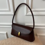Dark brown bag resting elegantly on a textured chair