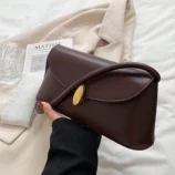 Dark brown evening purse held gracefully in hand