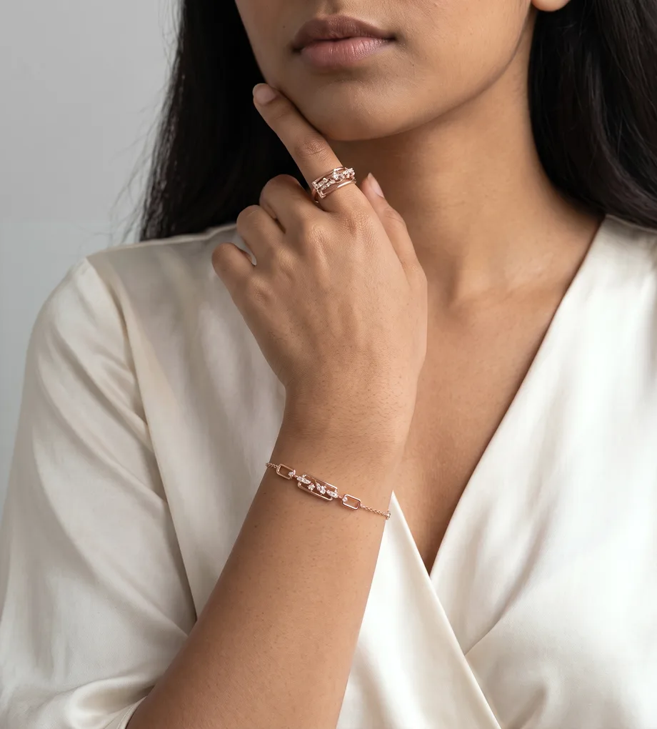 Woman wearing a rose gold link bracelet with clear crystals and a matching ring