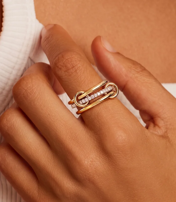 Elegant gold stainless steel multi-layer ring with sparkling accents worn on hand.