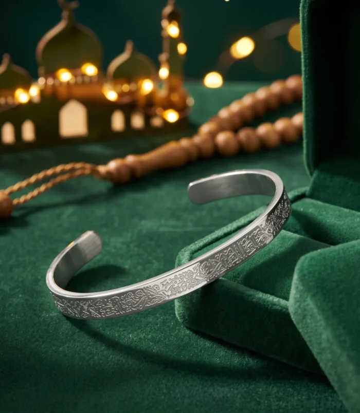Silver tone stainless steel cuff bracelet displayed with green velvet box and prayer beads.