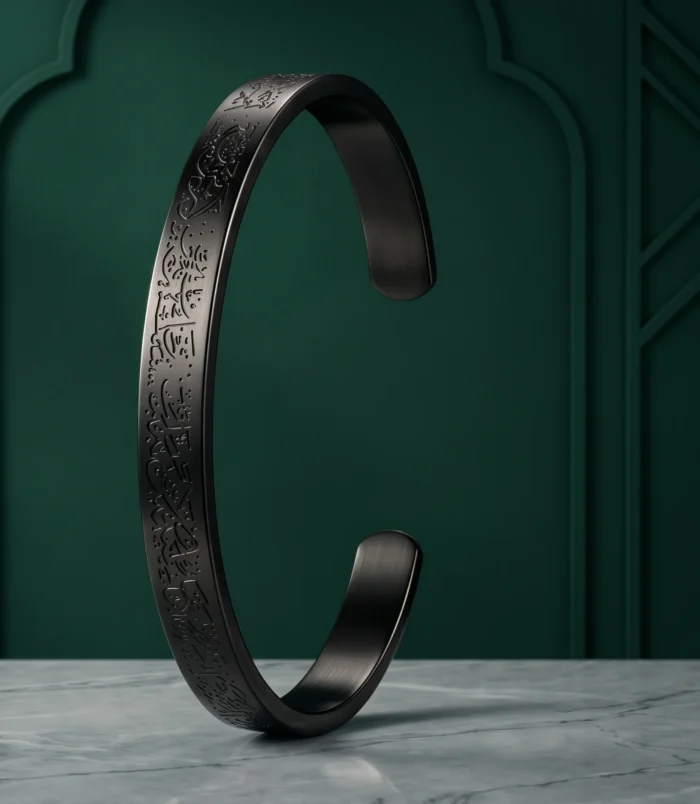 Black stainless steel cuff bracelet standing upright on a dark green background.