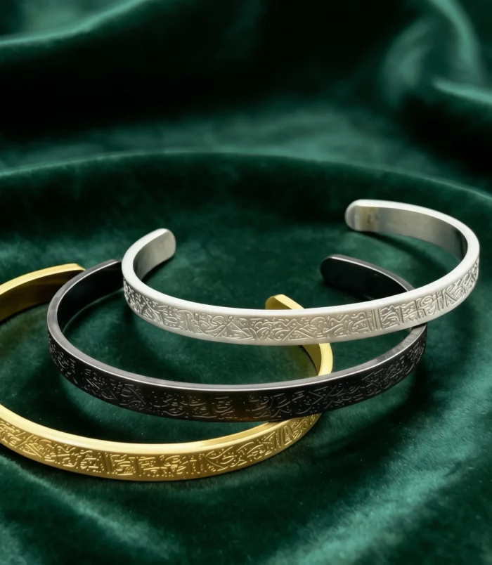 Elegant stainless steel cuff bracelet in gold silver and black colors stacked together.